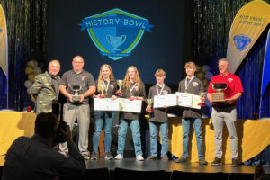 SMS WV History Bowl Champs on stage holding checks and trophies.