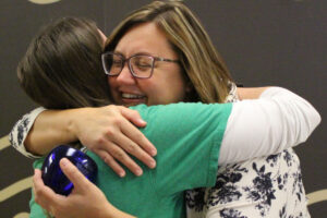 Alexa Bushovisky shares a joyful hug with Kathleen Loughman, Science Department Chair, after being surprised to learn that Kathleen nominated her for the Above and Beyond Award.