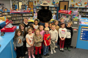 Ms. Callahan's kindergarten students learned about Smokey’s Five Rules of Wildfire Prevention, including the importance of never playing with matches and being careful around fire. The class is pictured with Smokey Bear.